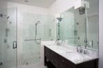 A recently updated bathroom with marble floors, granite counter tops, and a new tile lined shower.