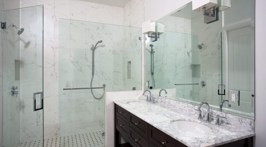 A recently updated bathroom with marble floors, granite counter tops, and a new tile lined shower.