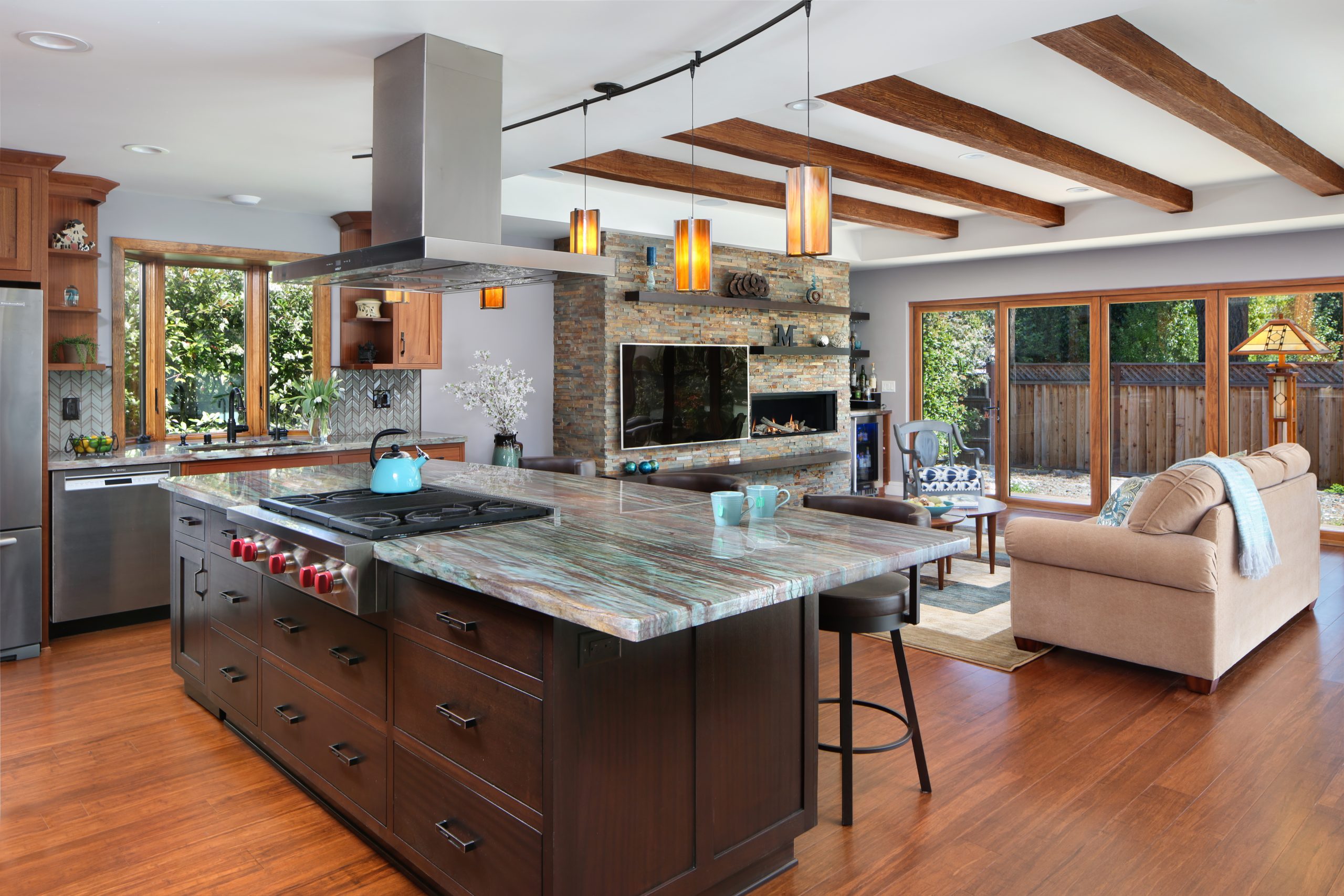 A kitchen island with granite counter tops and built in gas stove.