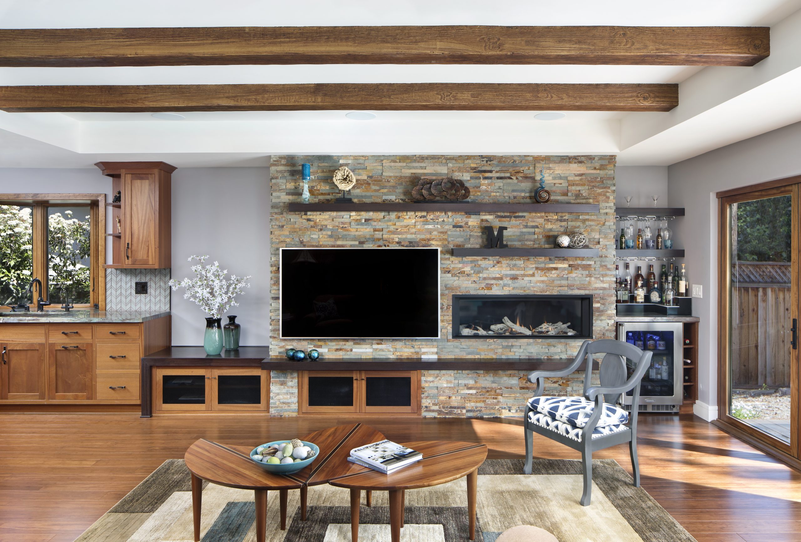 A modern living room with a built in wine refrigerator.