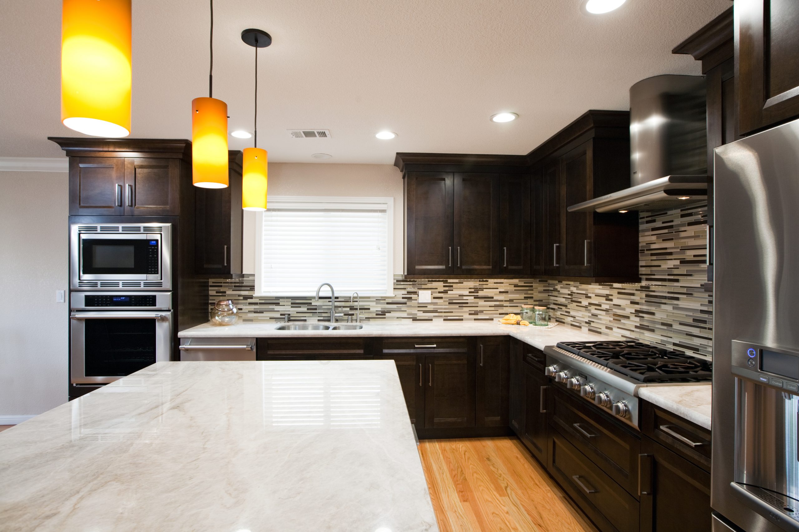 A modern kitchen with stainless steel appliances, tile back splash, and granite counter tops.