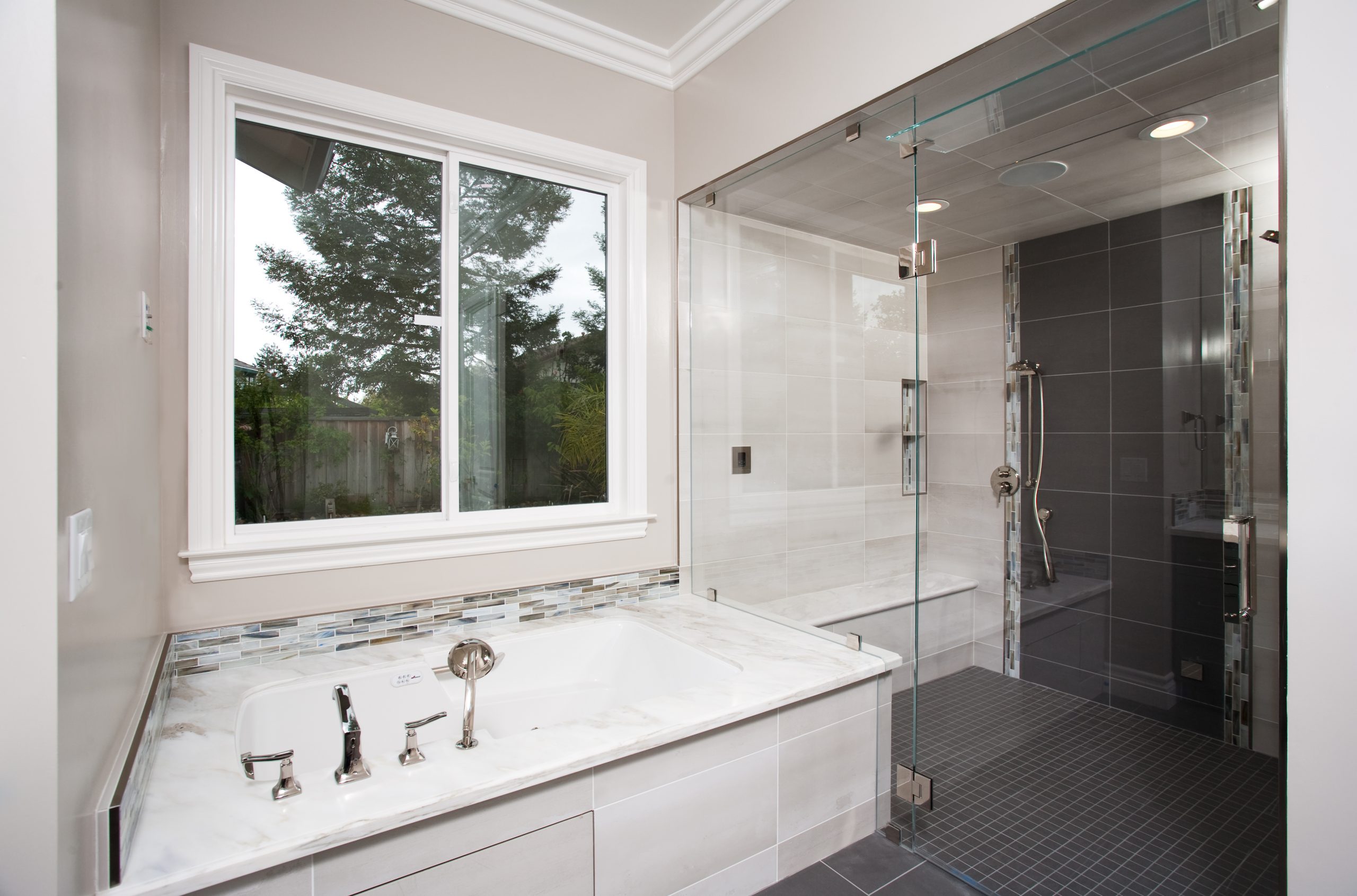 A master bathroom with Jacuzzi tub and large walk in glass shower.